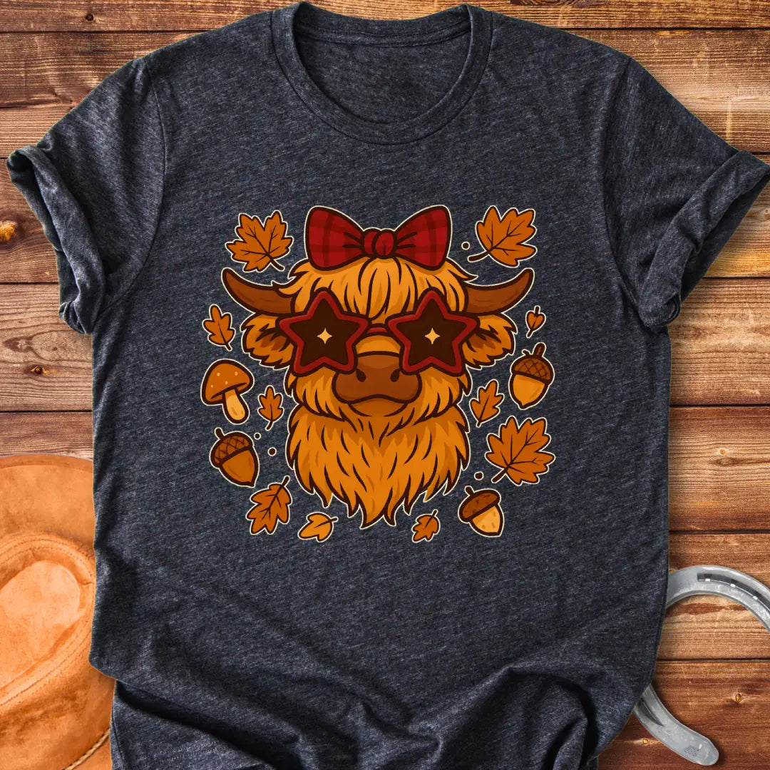 Cartoon illustration of a Highland cow wearing star-shaped sunglasses and a bow, surrounded by acorns, mushrooms, and fall leaves.