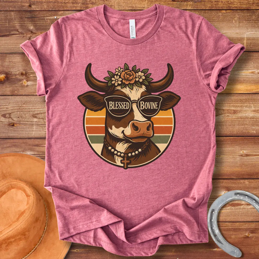 Blessed Bovine T-shirt design featuring a cow wearing sunglasses that say blessed bovine with a floral crown and a rosary.