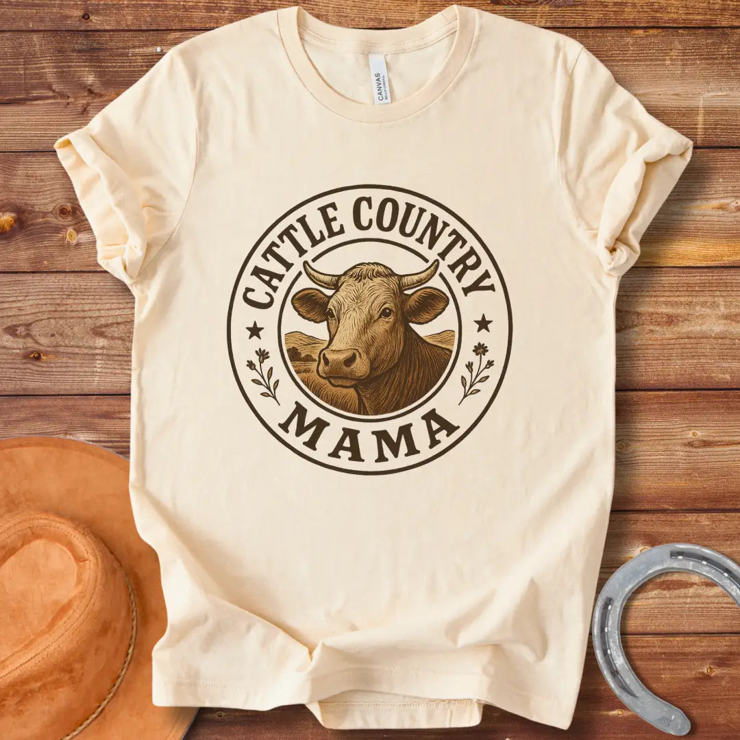 A sepia-toned illustration of a cow's head, surrounded by a circular design that reads 'Cattle Country Mama'.