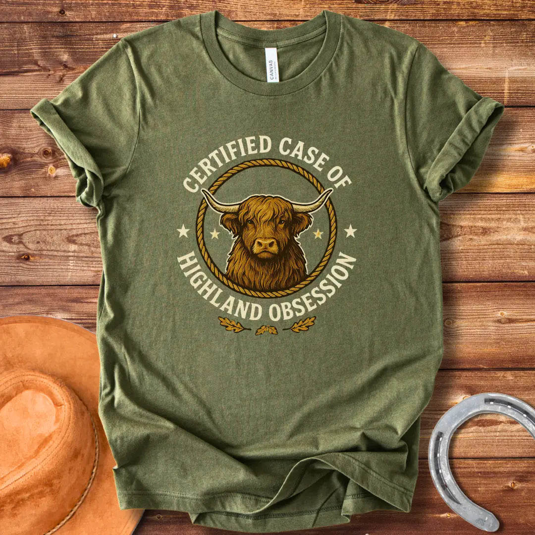 Certified Case of Highland Obsession T-Shirt featuring a detailed illustration of a Highland cow within a rope circle.