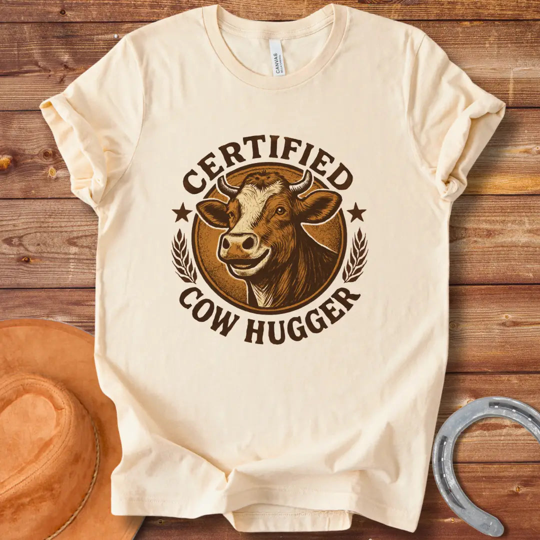 Certified Cow Hugger T-Shirt featuring a smiling cow illustration inside a circular emblem.