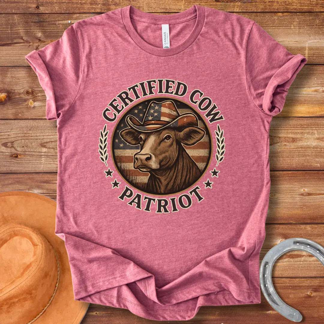 Certified Cow Patriot T-Shirt featuring a cow wearing an American flag cowboy hat, surrounded by stars and wheat stalks.