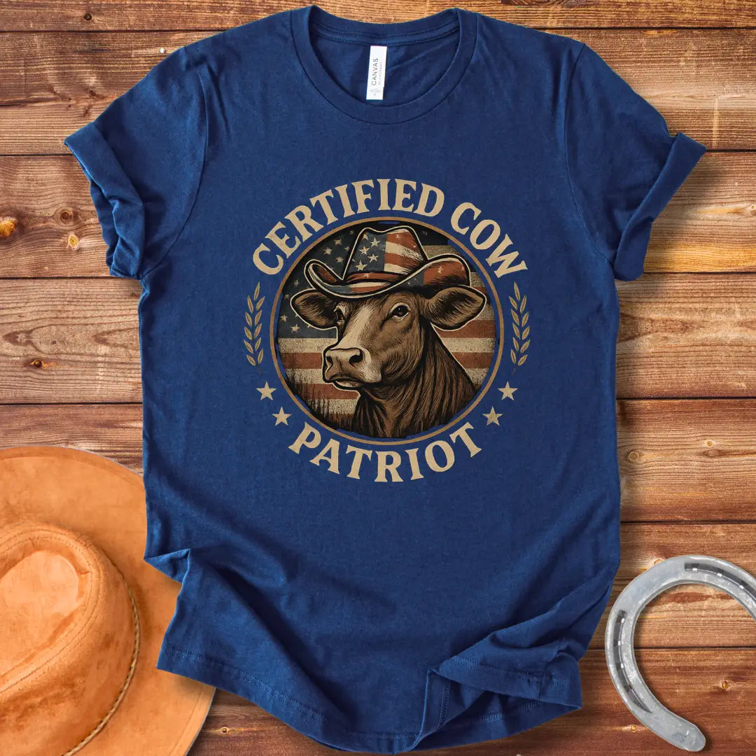 Certified Cow Patriot T-Shirt featuring a cow wearing an American flag cowboy hat, surrounded by stars and wheat stalks.