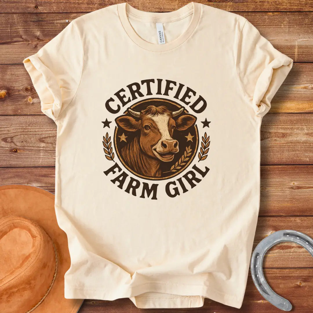 Certified Farm Girl T-Shirt design featuring a smiling cow's face inside a circular emblem with stars and wheat, perfect for cow lovers.