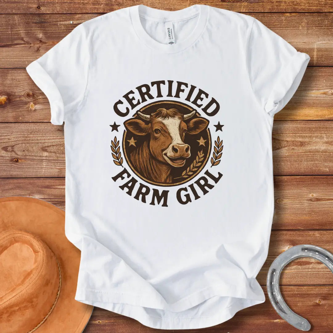 Certified Farm Girl T-Shirt design featuring a smiling cow's face inside a circular emblem with stars and wheat, perfect for cow lovers.