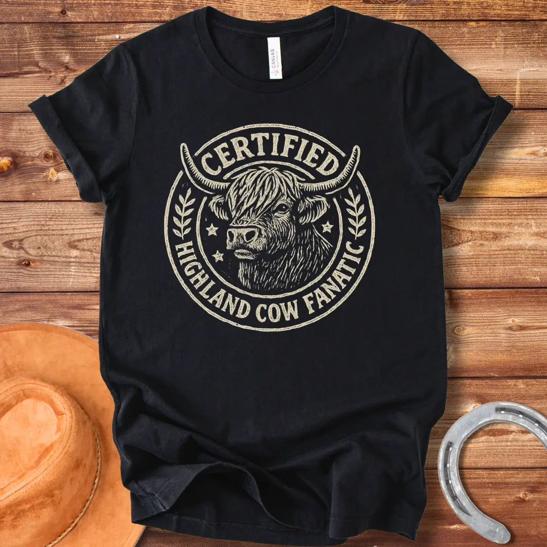 Certified Highland Cow Fanatic T-Shirt design, featuring a detailed illustration of a Highland cow within a circular badge with text.