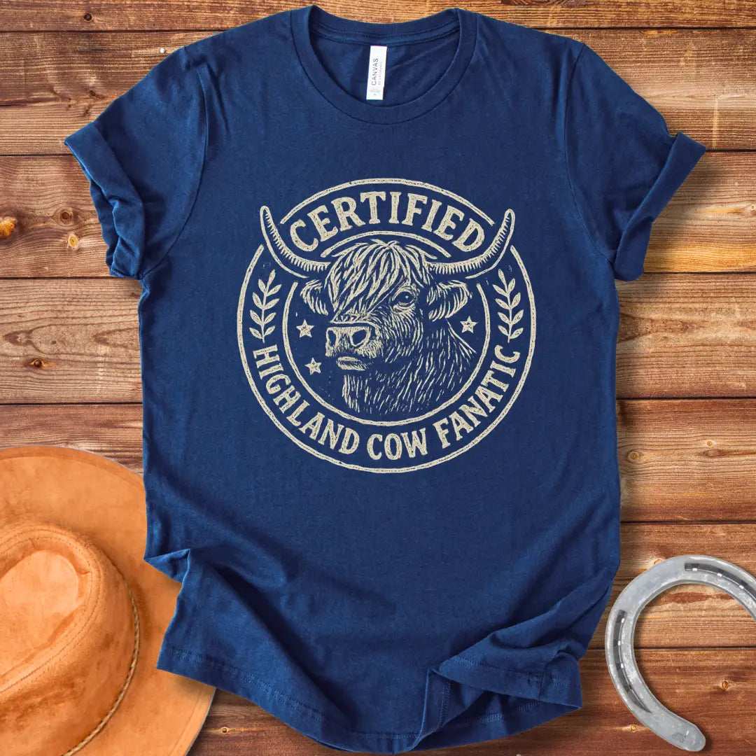 Certified Highland Cow Fanatic T-Shirt design, featuring a detailed illustration of a Highland cow within a circular badge with text.