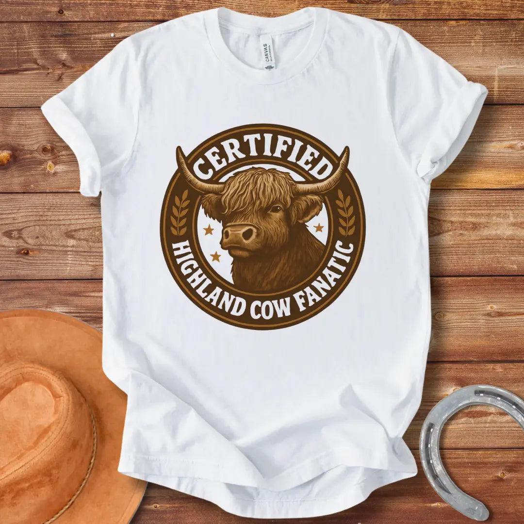 Certified Highland Cow Fanatic T-Shirt design, featuring a detailed illustration of a Highland cow within a circular badge with text.