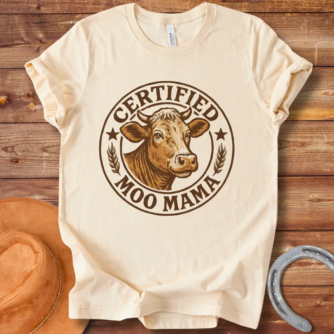 Certified Moo Mama T-shirt design with a detailed illustration of a cow's head inside a seal with the words 'Certified Moo Mama' around the edge.