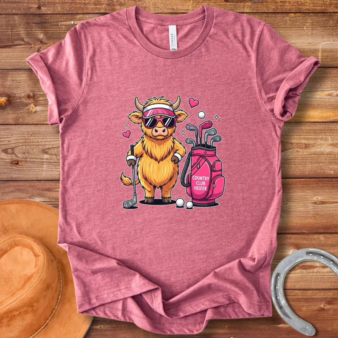 Cartoon illustration of a stylish Highland cow wearing sunglasses and a visor, holding a golf club next to a golf bag that reads 'Country Club Heifer.'