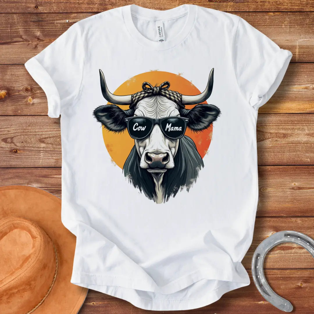 Cow Mama T-Shirt featuring a cool cow wearing sunglasses that say 'Cow Mama', against an orange sun.