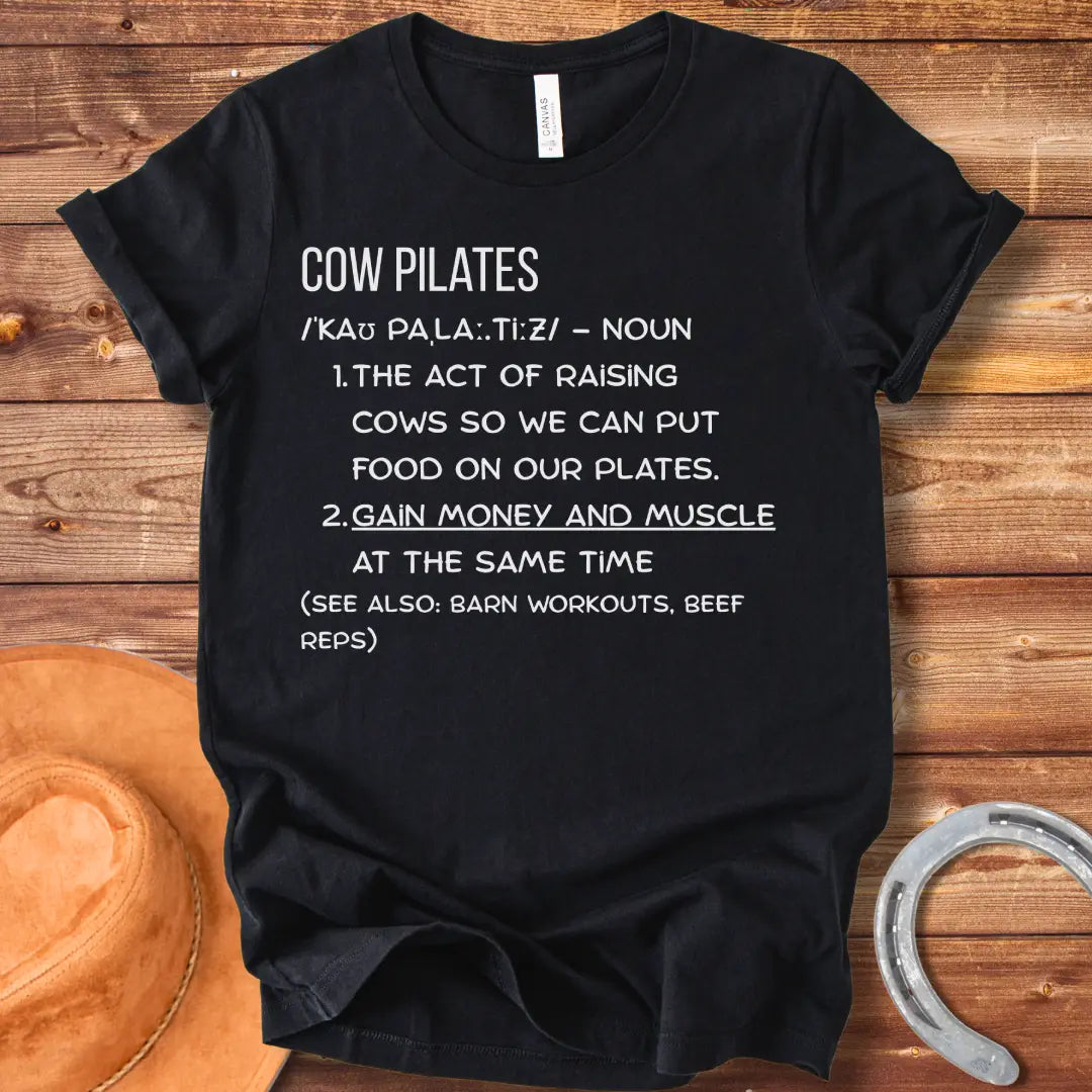 A stylish black t-shirt design featuring a cow doing pilates, against a black background.