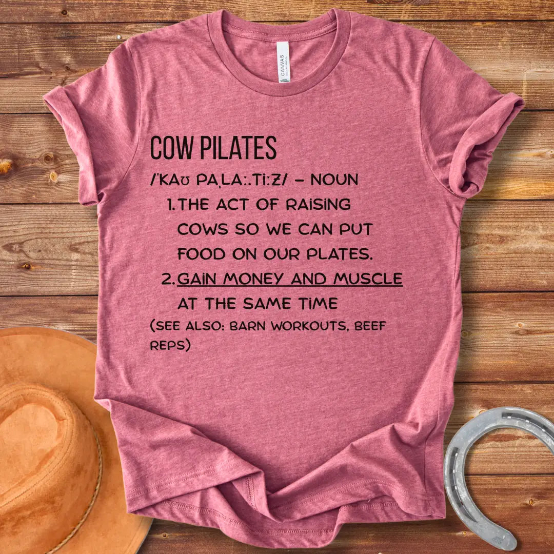 A stylish black t-shirt design featuring a cow doing pilates, against a black background.