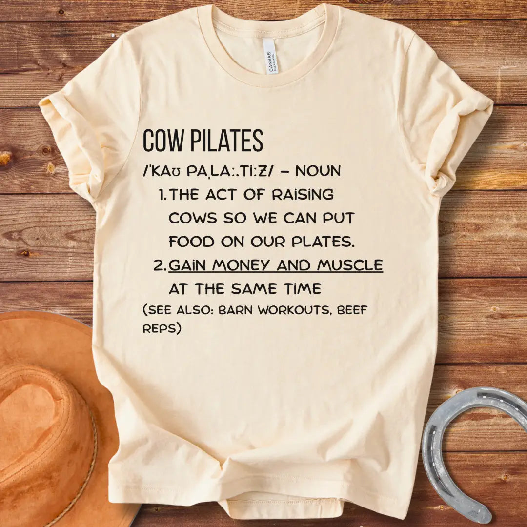 A stylish black t-shirt design featuring a cow doing pilates, against a black background.