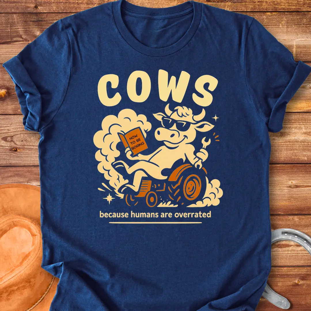 Funny t-shirt design featuring a cool cow reading a book on a tractor with the phrase 'Cows Because Humans Overrated'