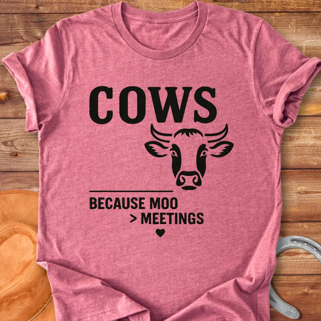 Black and white t-shirt design featuring a cow's face with the words Cows Because Moo Better Than Meetings