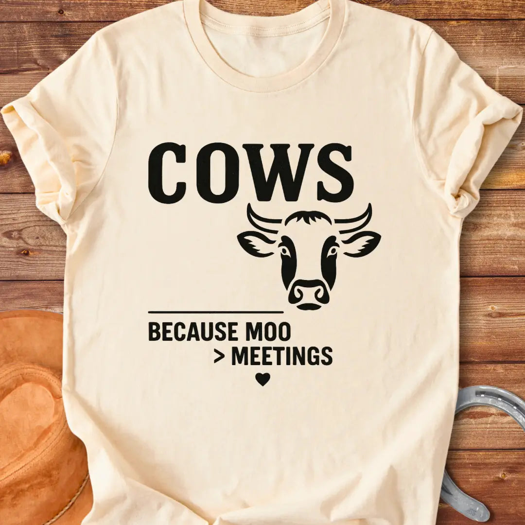 Black and white t-shirt design featuring a cow's face with the words Cows Because Moo Better Than Meetings