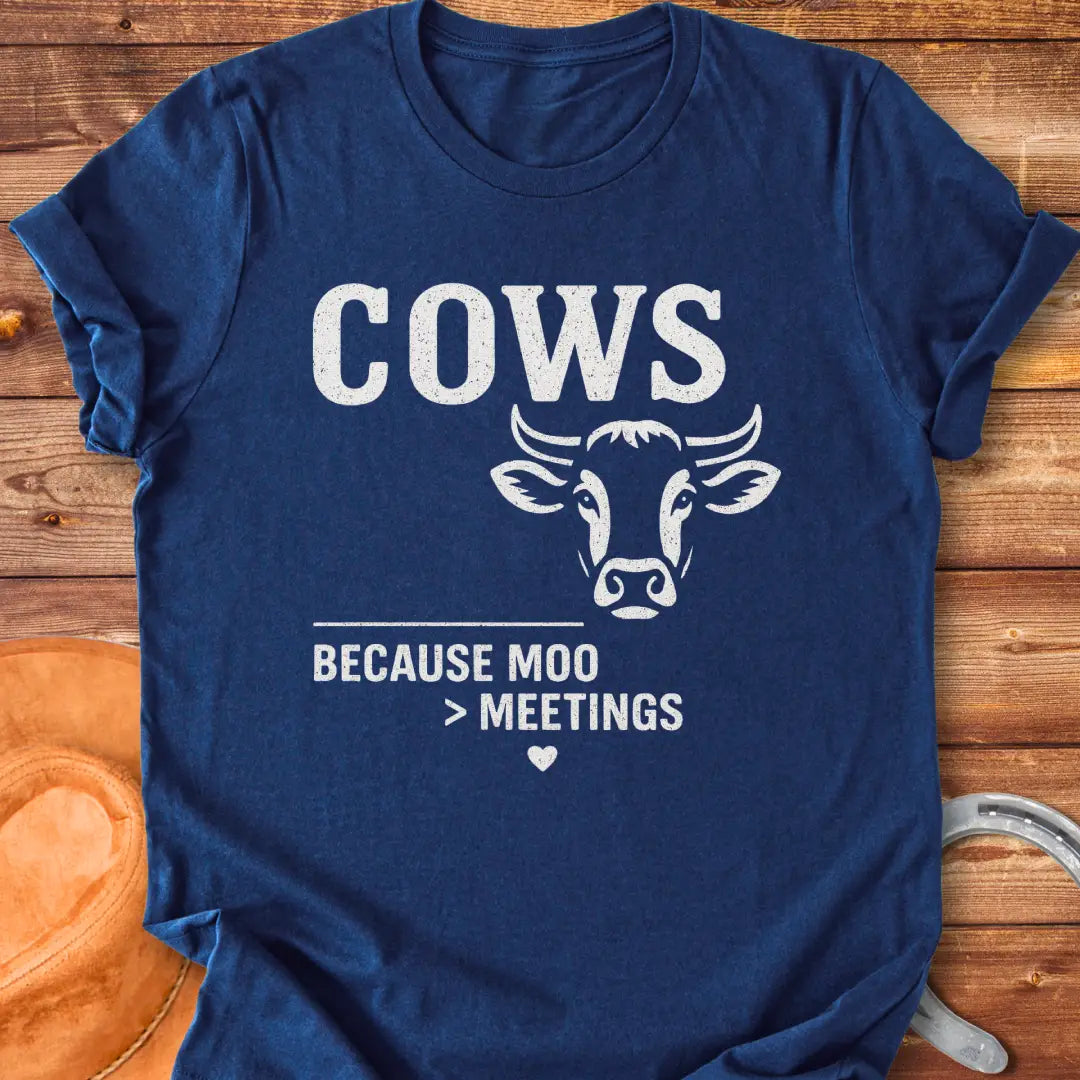 Black and white t-shirt design featuring a cow's face with the words Cows Because Moo Better Than Meetings