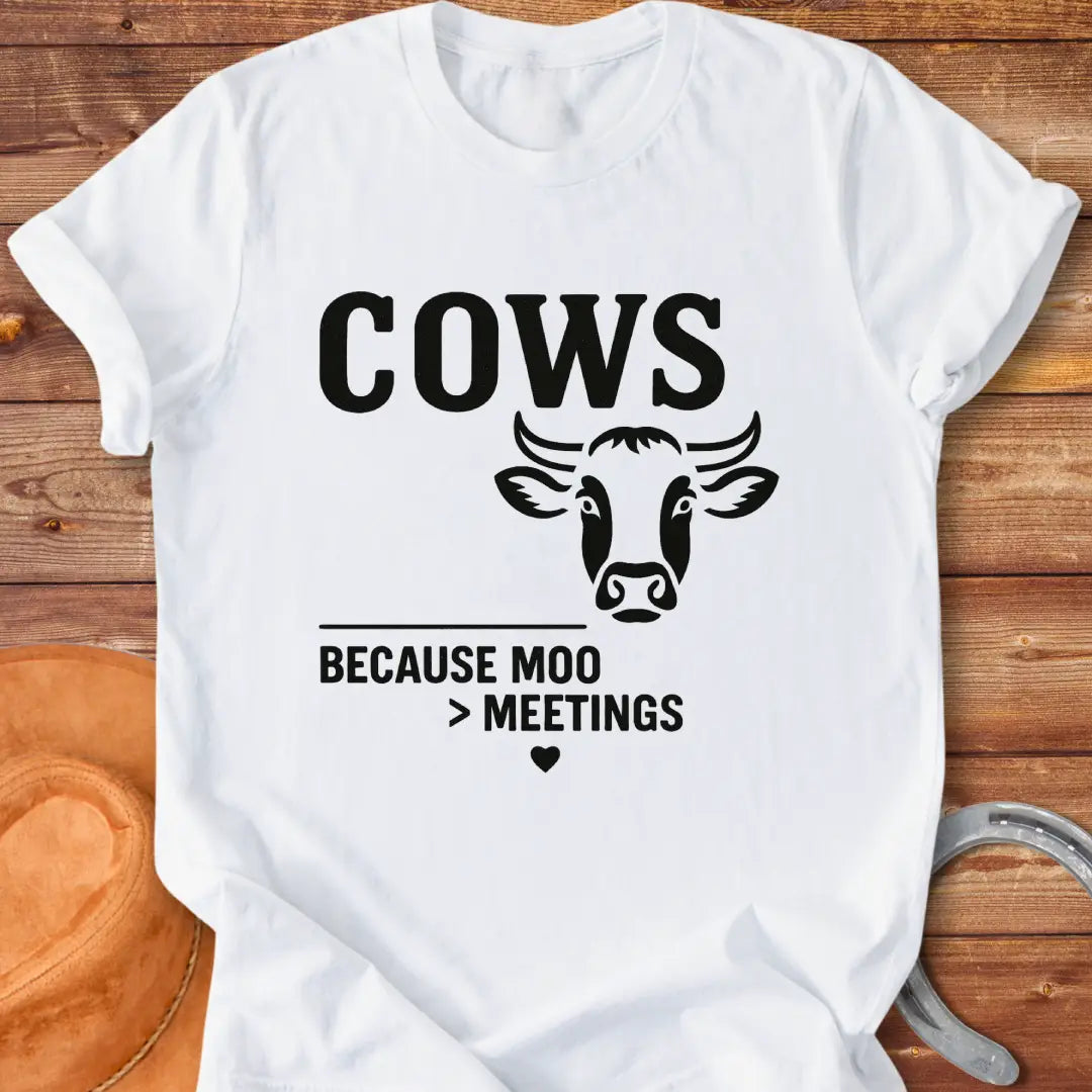 Black and white t-shirt design featuring a cow's face with the words Cows Because Moo Better Than Meetings