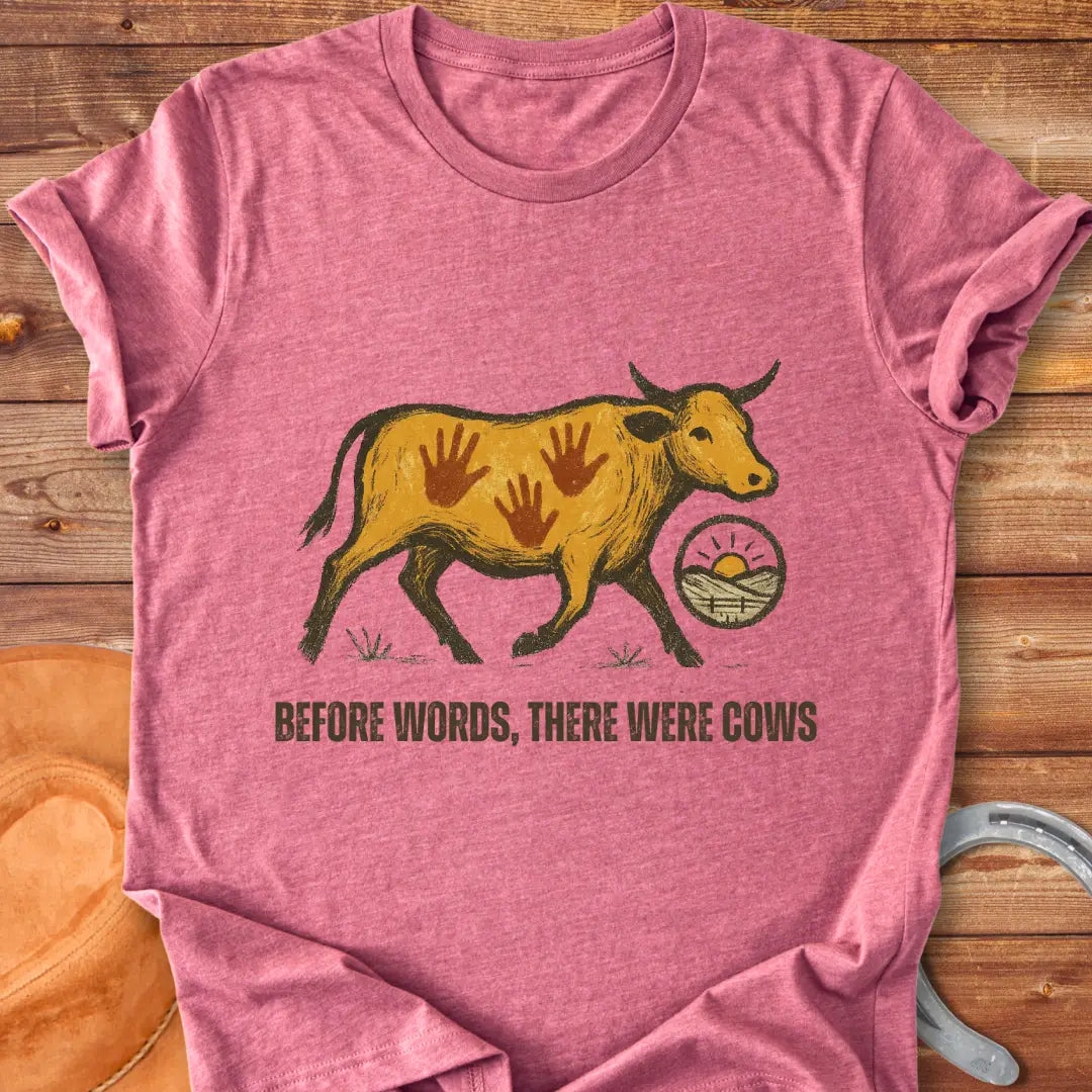 Vintage-style t-shirt design featuring a cow with handprints and the words "Before Words, There Were Cows."