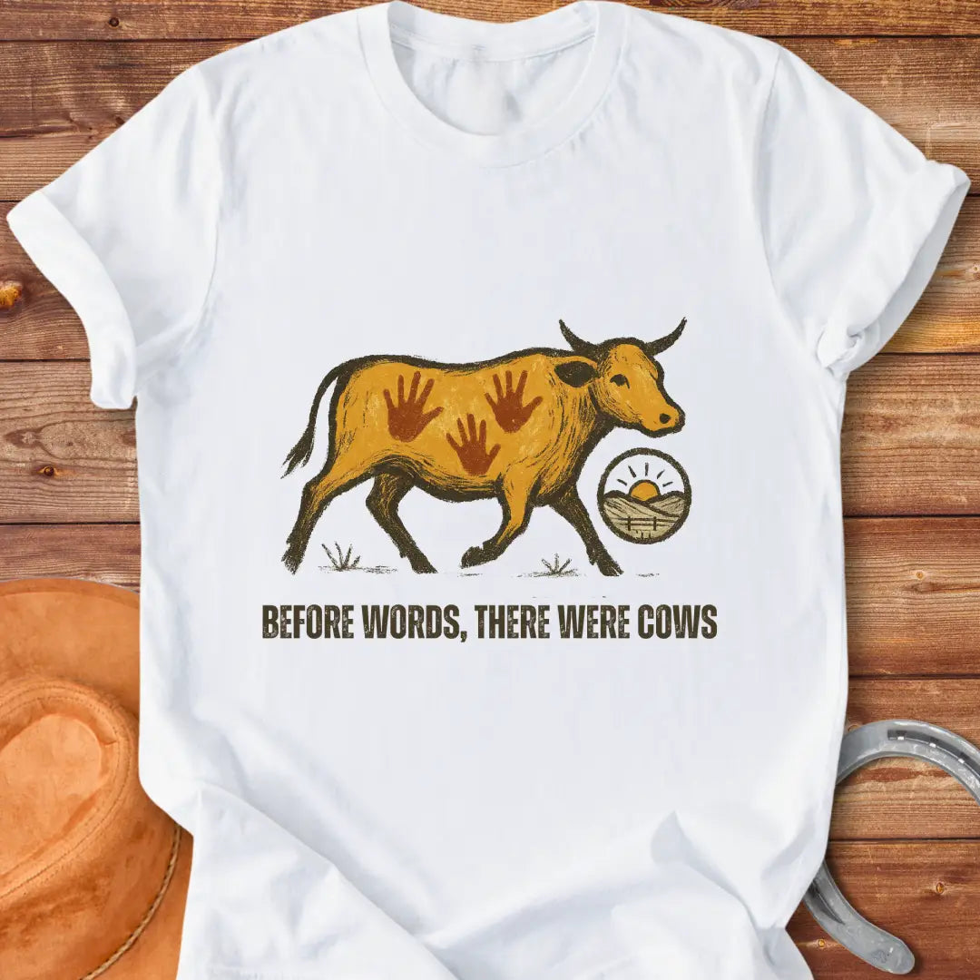 Vintage-style t-shirt design featuring a cow with handprints and the words "Before Words, There Were Cows."
