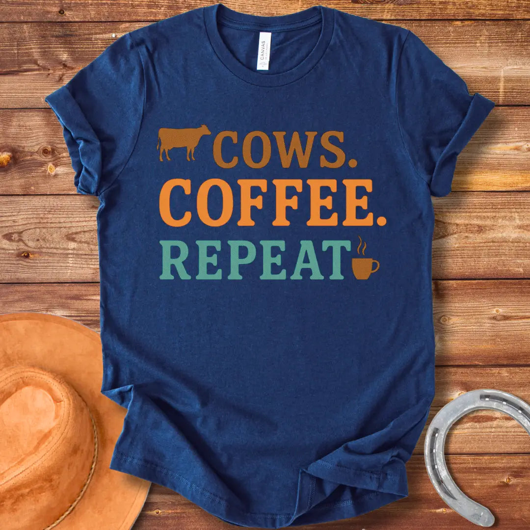 Graphic design on a t-shirt showing a cow silhouette followed by the words 'COWS. COFFEE. REPEAT.' and a coffee cup icon.
