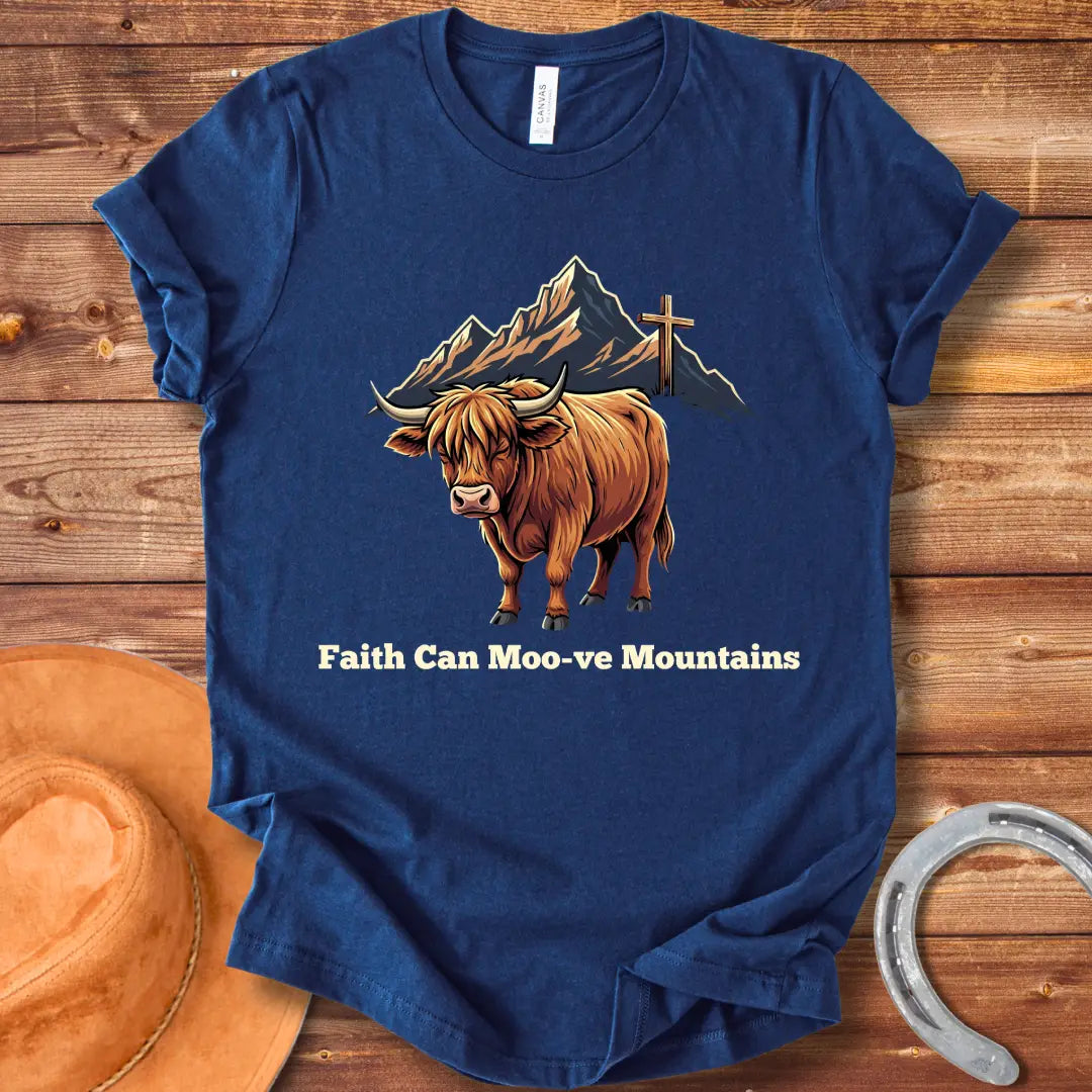Highland cow graphic t-shirt with the words 'Faith Can Moo-ve Mountains', with mountain range and cross in the background