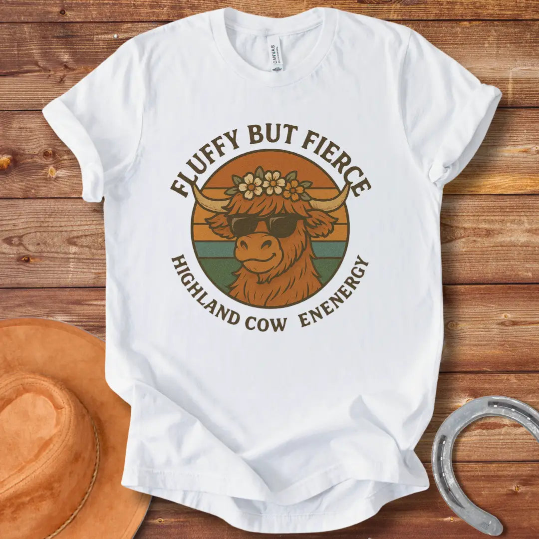 Fluffy but Fierce t-shirt featuring a Highland cow wearing sunglasses and a flower crown, with text reading 'Highland Cow Energy'