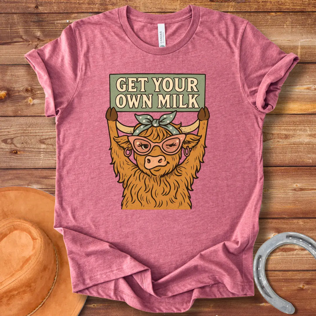 A sassy highland cow wearing sunglasses, holding a sign that reads 'Get Your Own Milk'