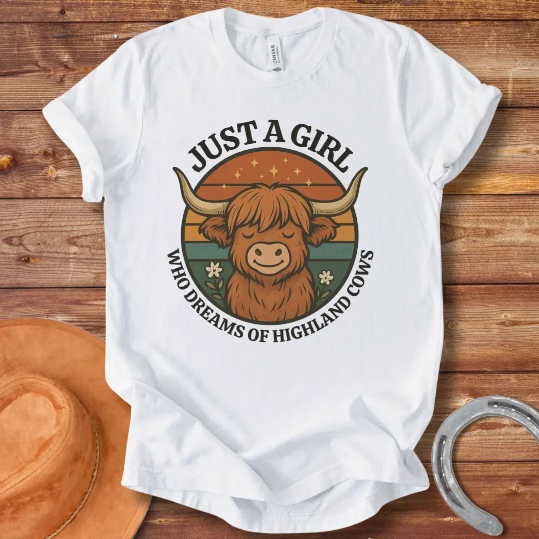 Girl Dreams of Highland Cows t-shirt with a cartoon illustration of a cute highland cow with the words "Just a girl who dreams of highland cows"