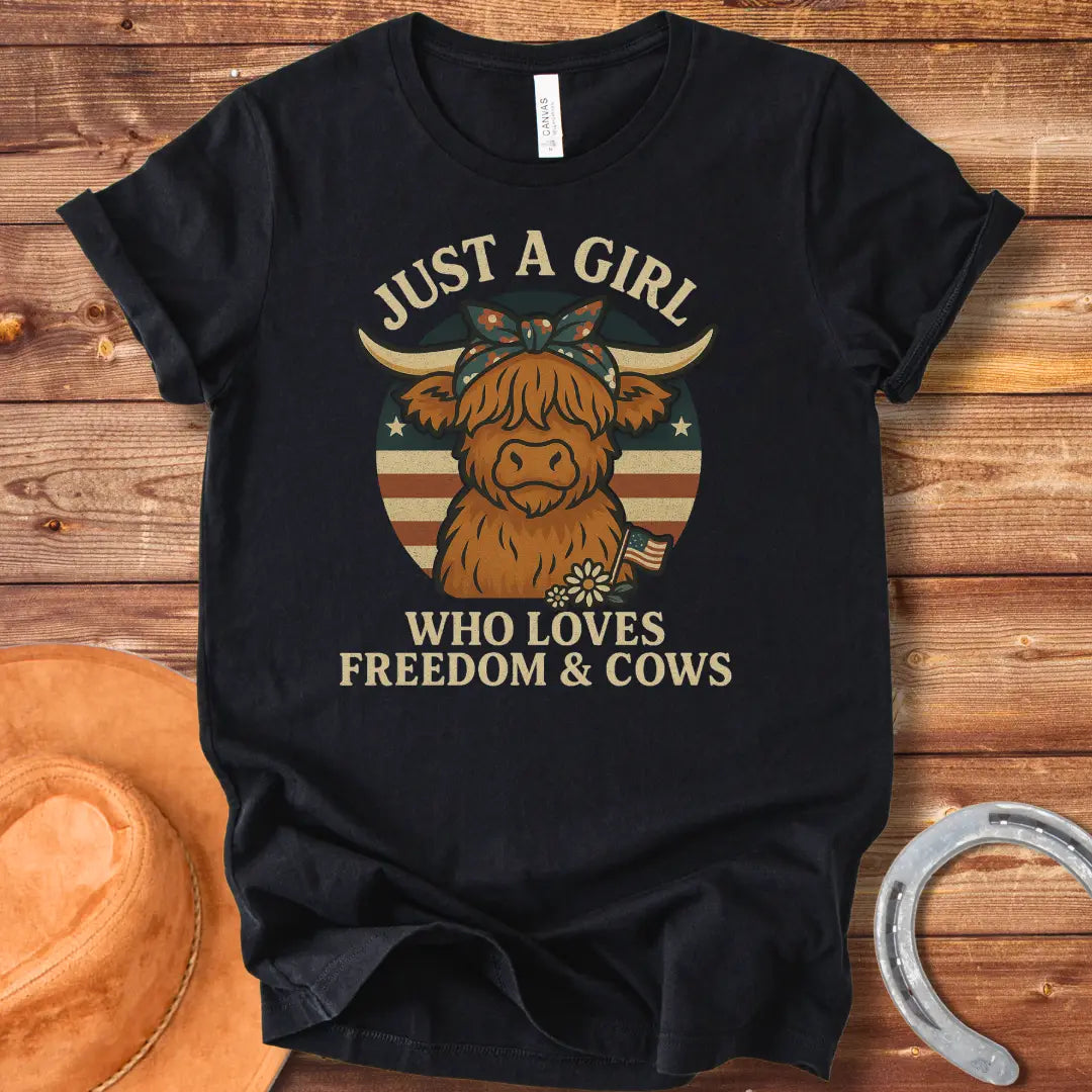 A cute Highland cow wearing a floral bandana, set against a patriotic American flag circle. Text reads 'Just a girl who loves freedom & cows'.