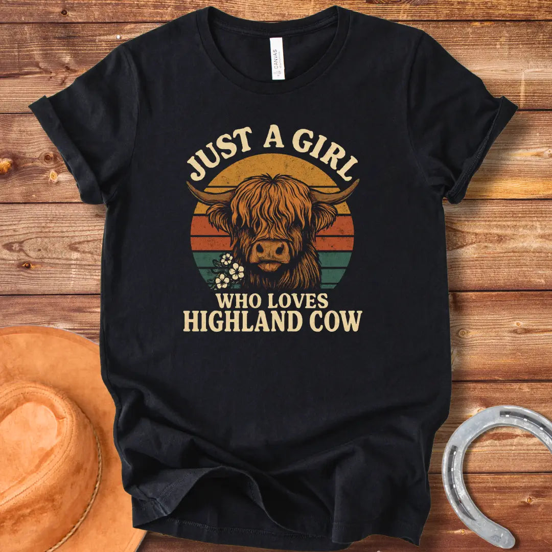 Vintage t-shirt featuring a Highland cow with flowers and the text 'Just a Girl Who Loves Highland Cow' against a retro sunset backdrop.