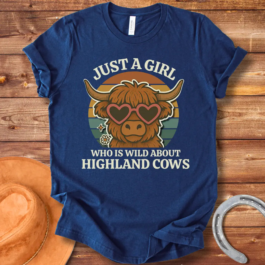 Girl Wild About Highland Cows t-shirt design featuring a Highland cow wearing heart-shaped sunglasses against a sunset backdrop.