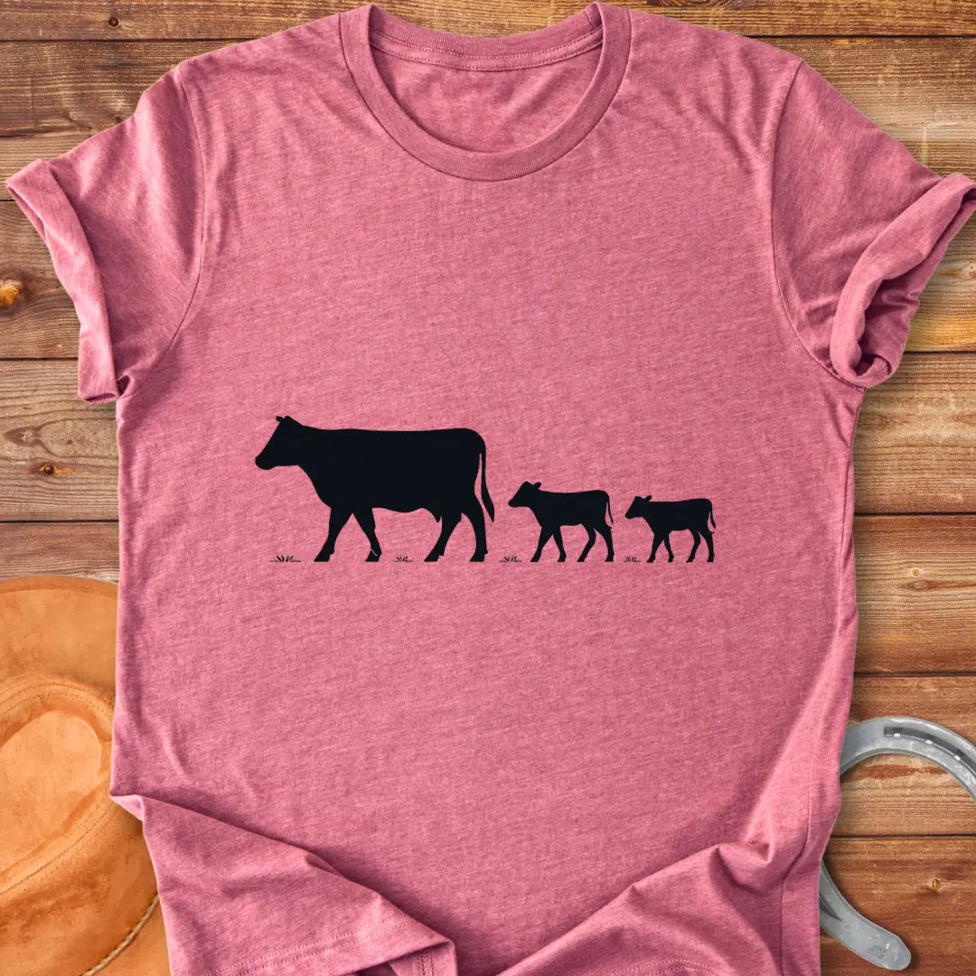 Silhouette of a cow family grazing, mother cow leading two calves