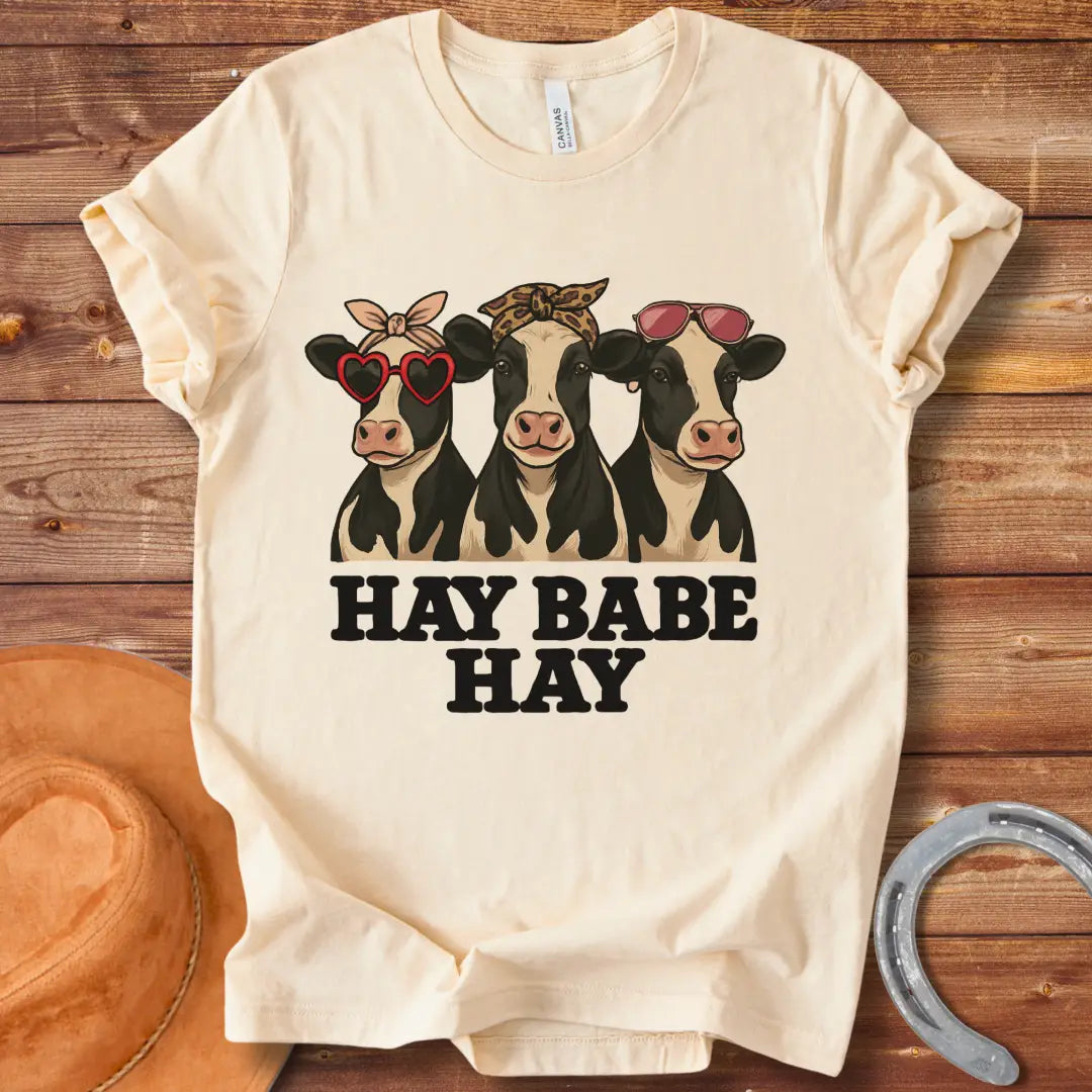 Hay Babe Hay T-Shirt featuring three stylish cows wearing sunglasses and bandanas. Text reads 'Hay Babe Hay'.