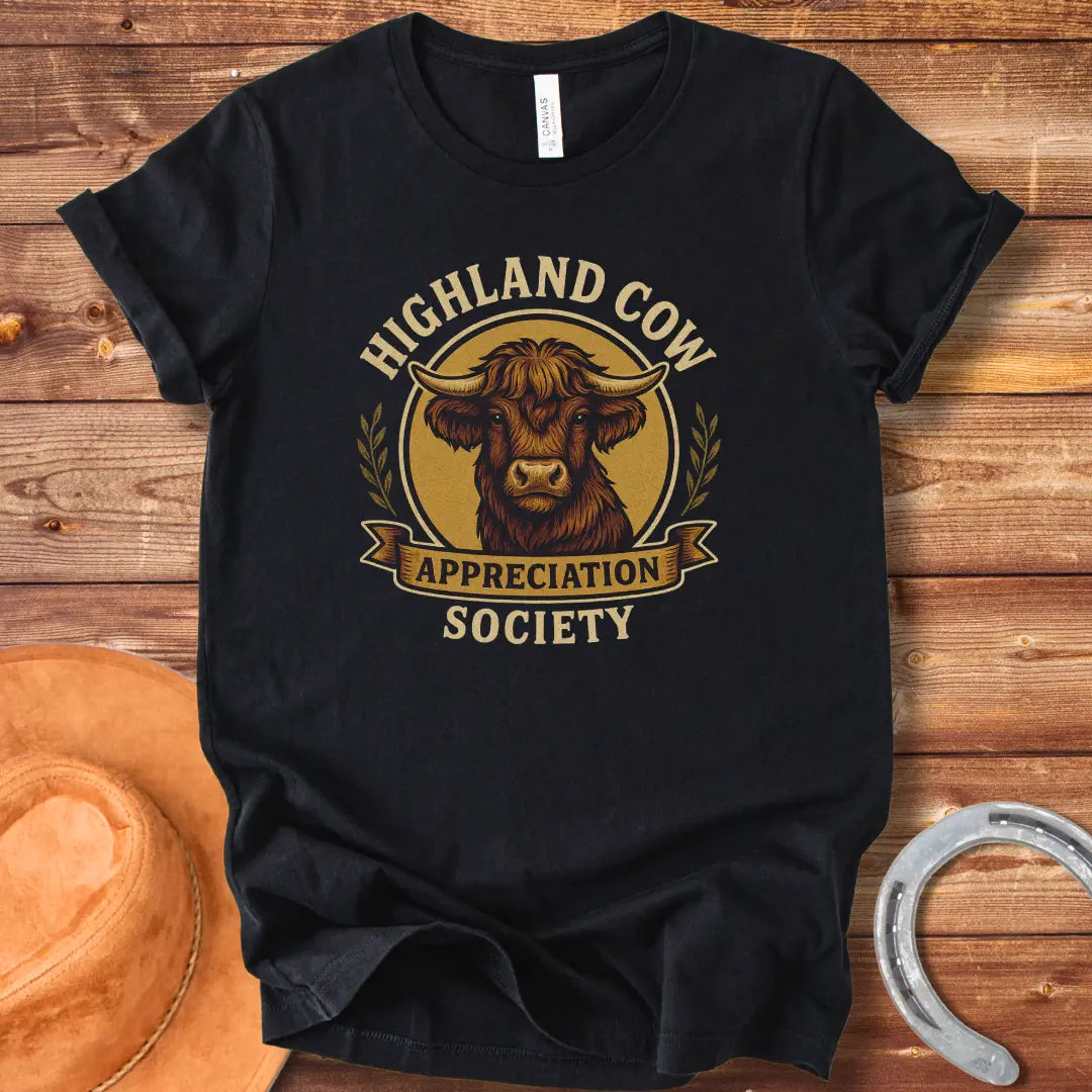 Highland Cow Appreciation Society T-Shirt featuring a detailed drawing of a highland cow with the words 'Highland Cow Appreciation Society' in a circular design.