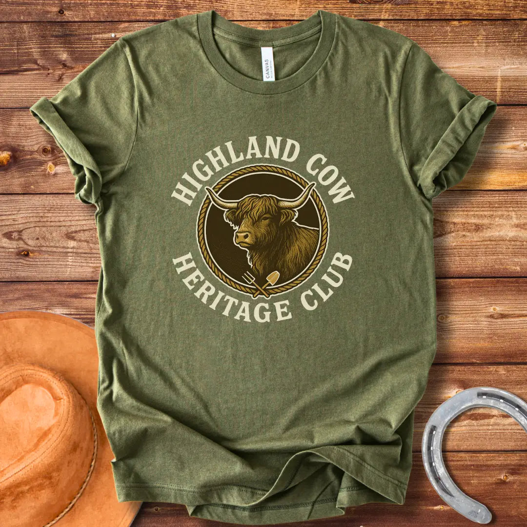 Highland Cow Heritage Club T-Shirt featuring a detailed illustration of a Highland cow with a rope circle and farm tools.