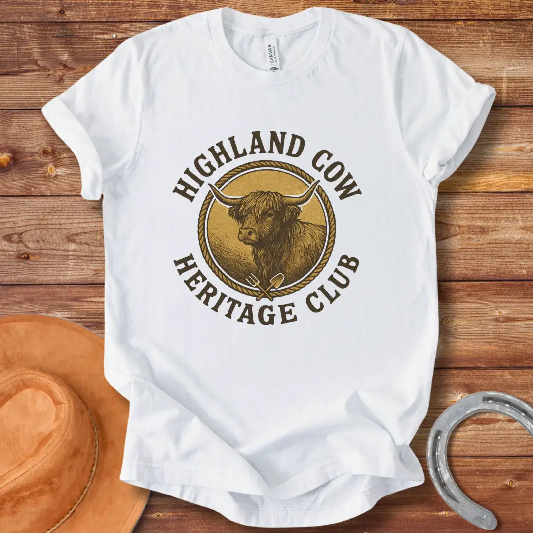 Highland Cow Heritage Club T-Shirt featuring a detailed illustration of a Highland cow with a rope circle and farm tools.