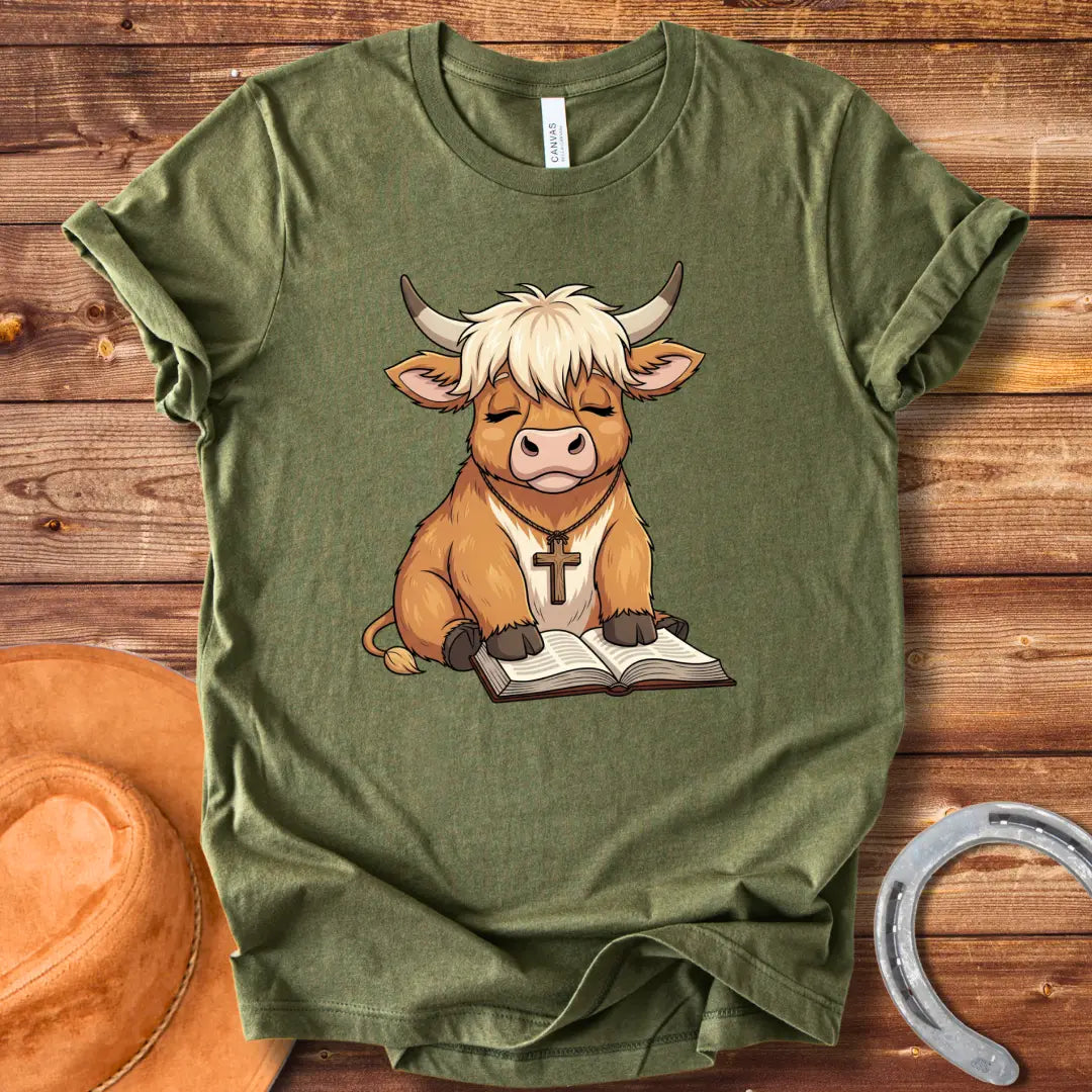 Cartoon illustration of a cow wearing a cross necklace, sitting peacefully with a book open in its lap.