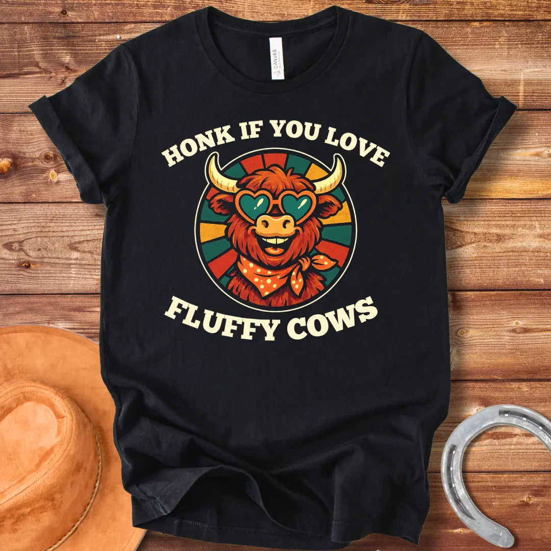 T-shirt design with a smiling cow wearing heart-shaped sunglasses and a bandana, with the text 'Honk If You Love Fluffy Cows'.