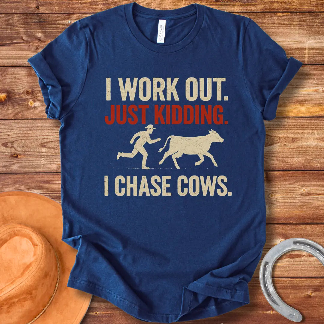 Vintage T-shirt with a humorous design of a person chasing a cow, with the words 'I Work Out. Just Kidding. I Chase Cows.'