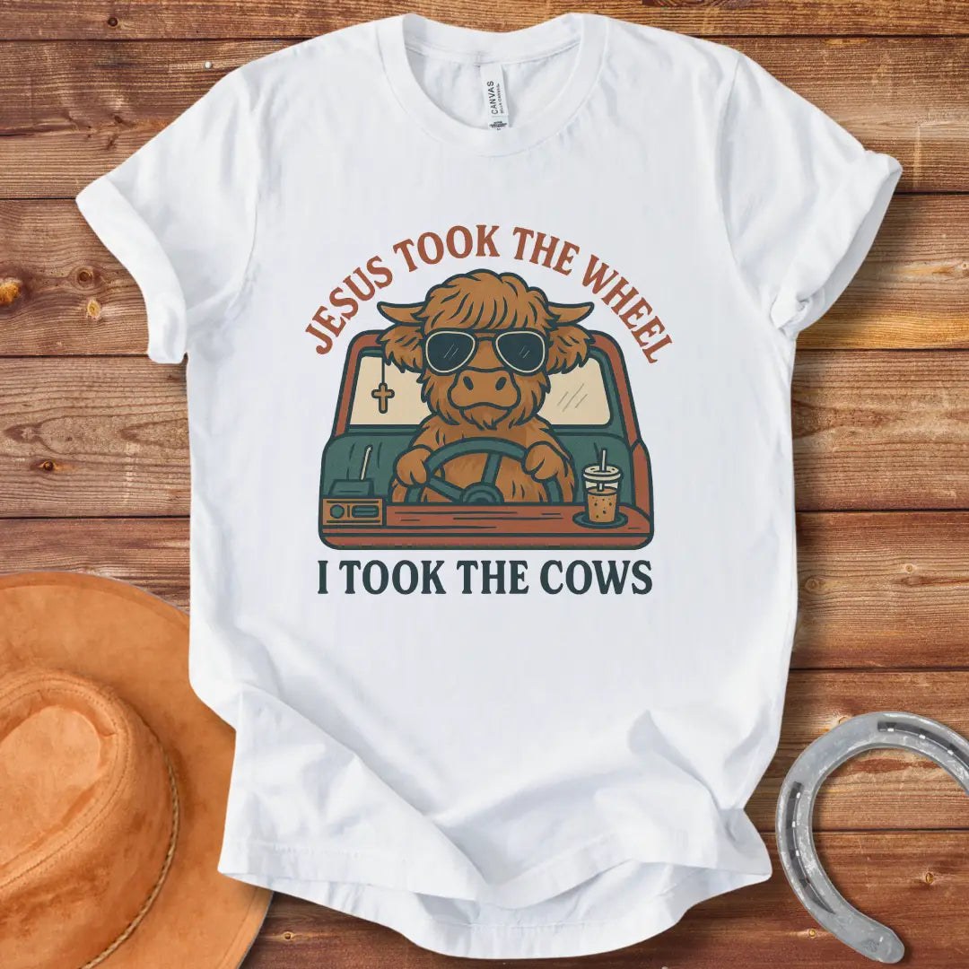 A Highland cow wearing sunglasses drives a car while holding a coffee; text reads 'Jesus took the wheel, I took the cows'.