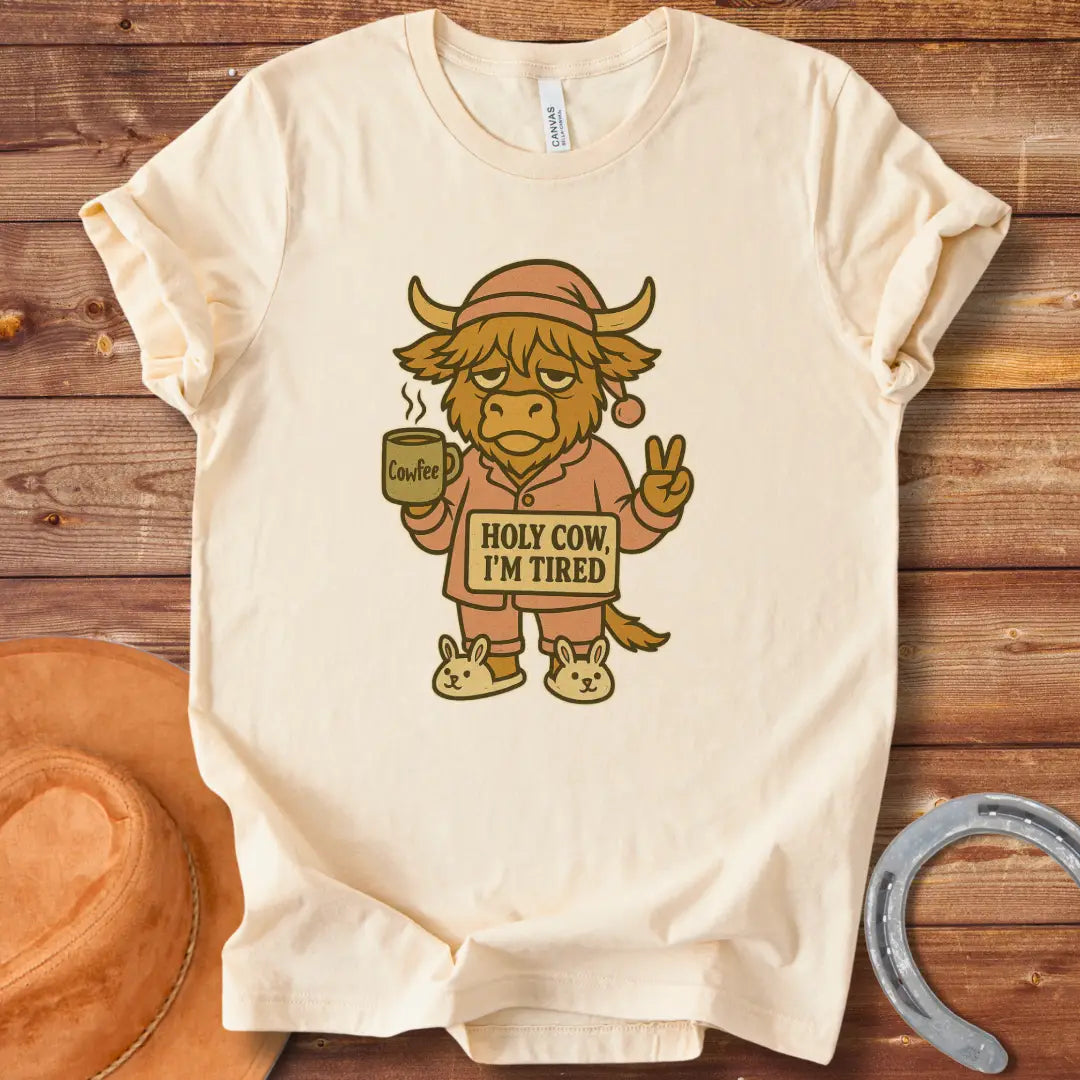 Illustration of a tired cow in pajamas holding a coffee mug that says 'Cowfee,' holding up a peace sign, and wearing bunny slippers. Text on the cow's sign reads 'Holy Cow, I'm Tired.'
