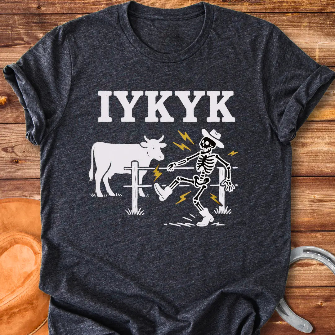 Funny graphic tee featuring a skeleton getting shocked by an electric fence with a cow in the background.