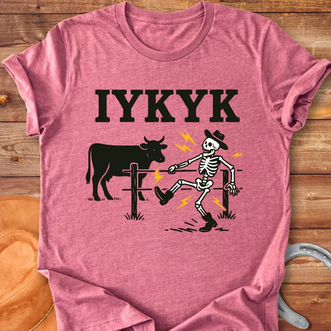 Funny graphic tee featuring a skeleton getting shocked by an electric fence with a cow in the background.
