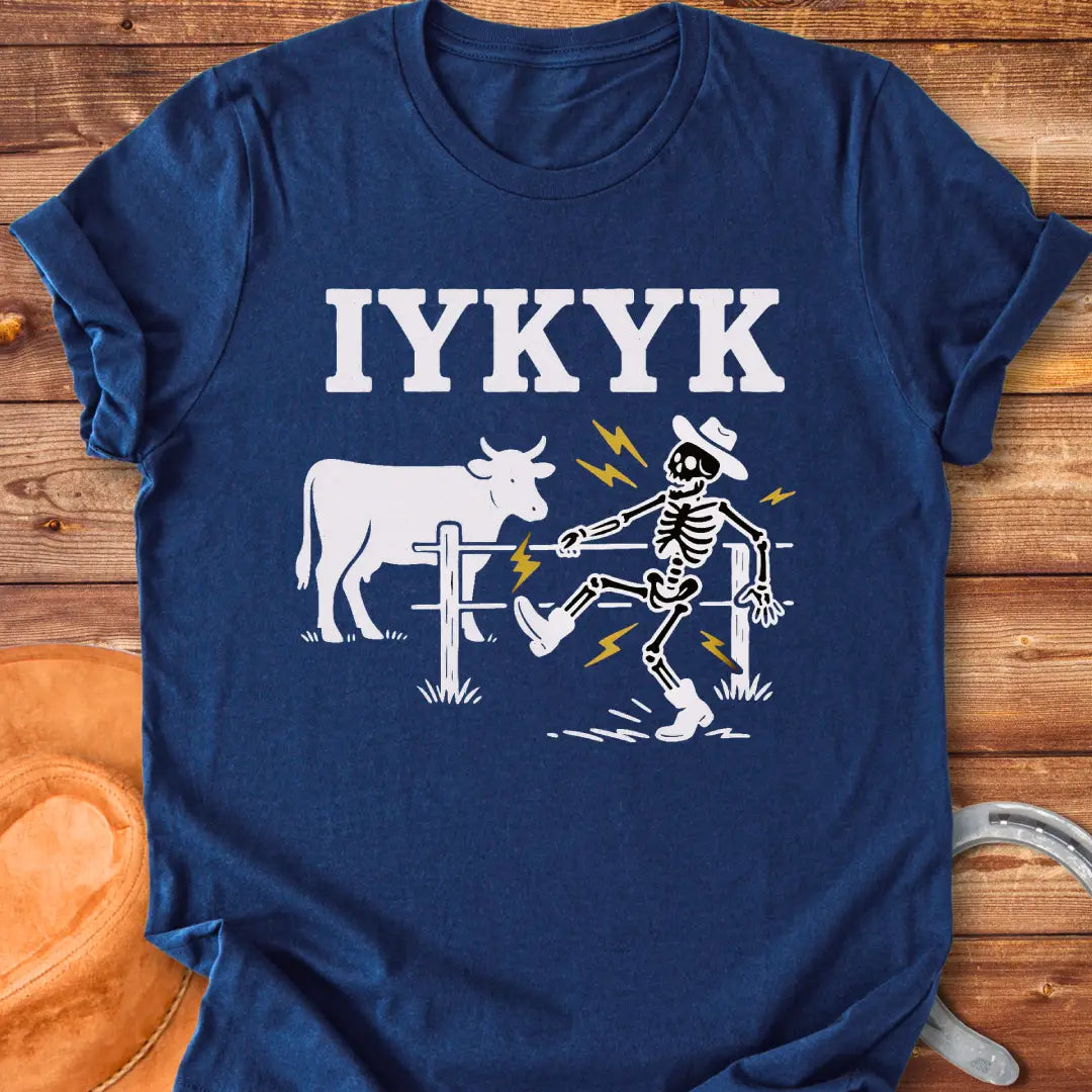 Funny graphic tee featuring a skeleton getting shocked by an electric fence with a cow in the background.