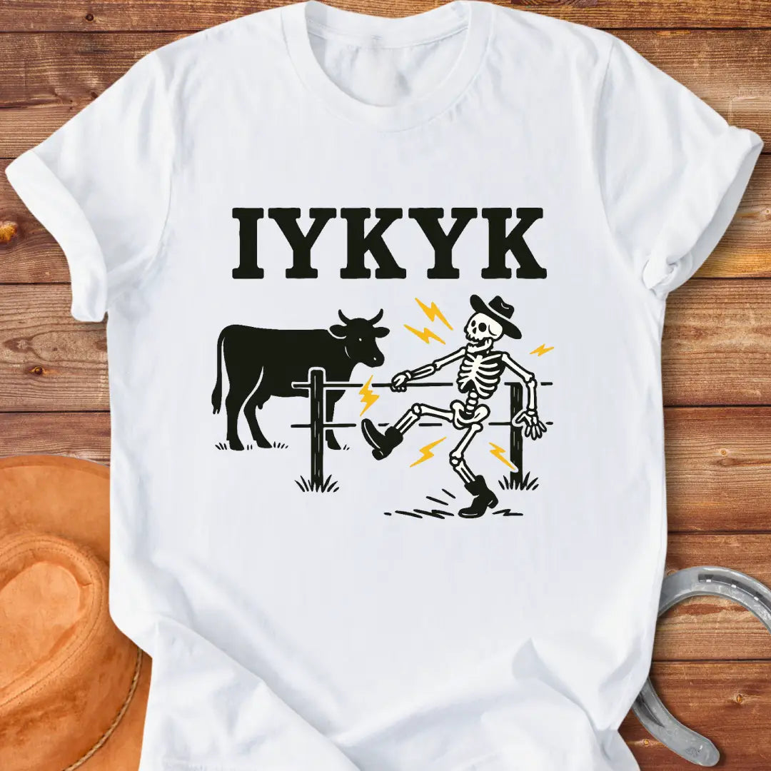 Funny graphic tee featuring a skeleton getting shocked by an electric fence with a cow in the background.
