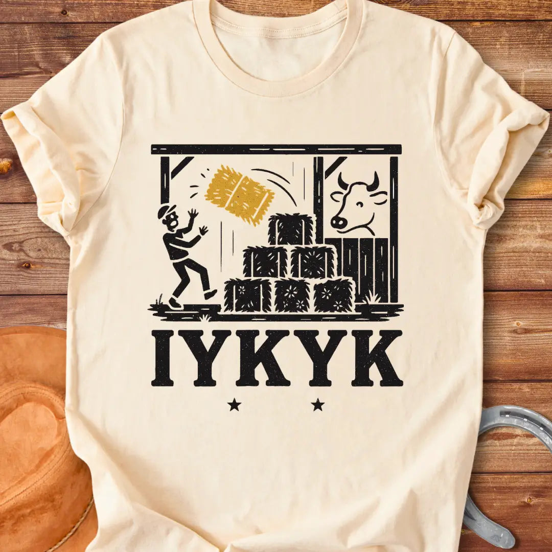 Funny t-shirt design featuring a person surprised by falling hay with a cow watching in the background.