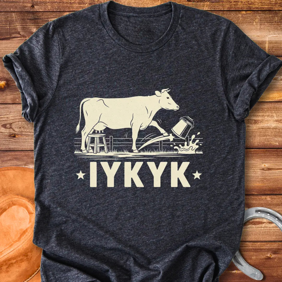 Illustration of a cow kicking a bucket, with the words 'IYKYK' and a farm scene background.
