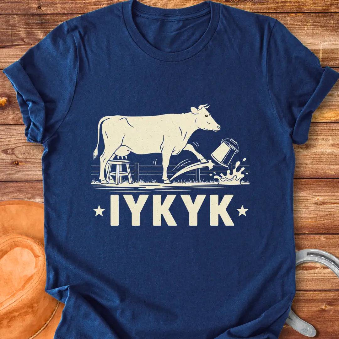 Illustration of a cow kicking a bucket, with the words 'IYKYK' and a farm scene background.